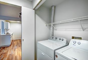 A white washing machine and dryer in a small laundry room at Woodlake Apartments, Kirkland, WA